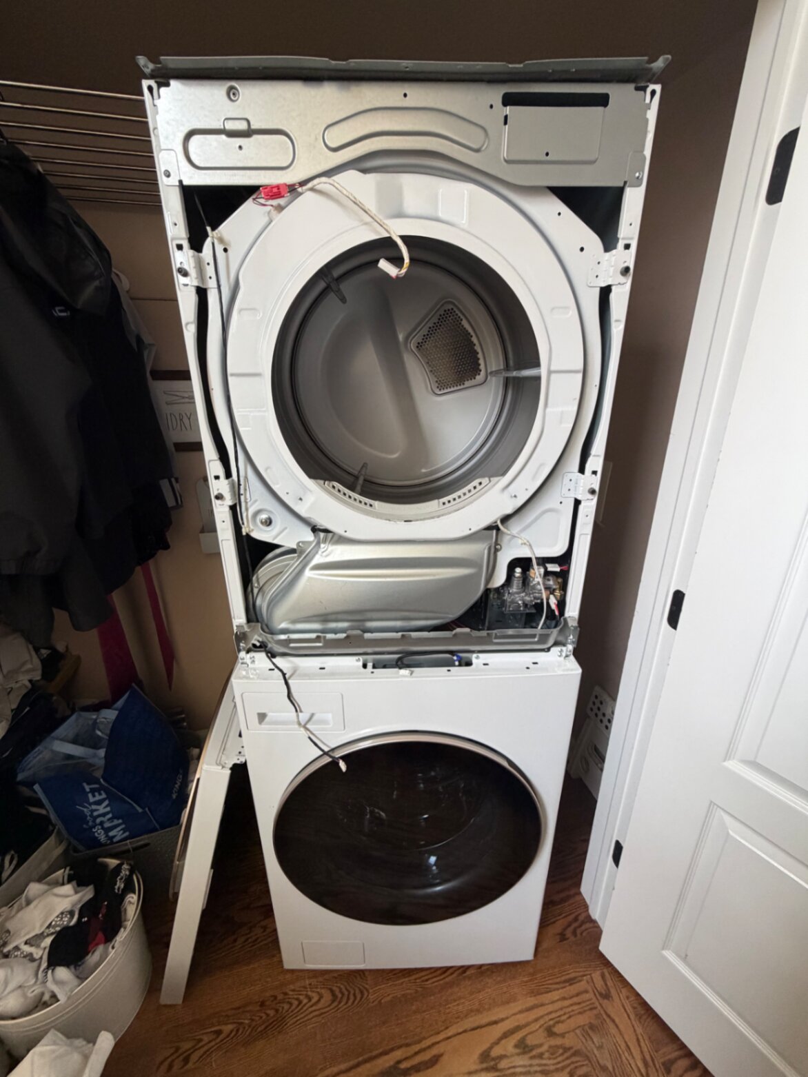 Stacked dryer repair with front panel removed in a customer home