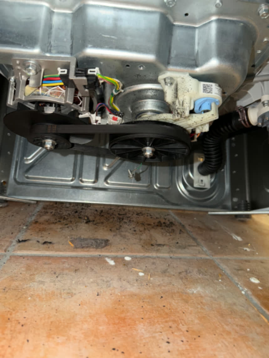 Washer belt drive and drain pump components inspected from below