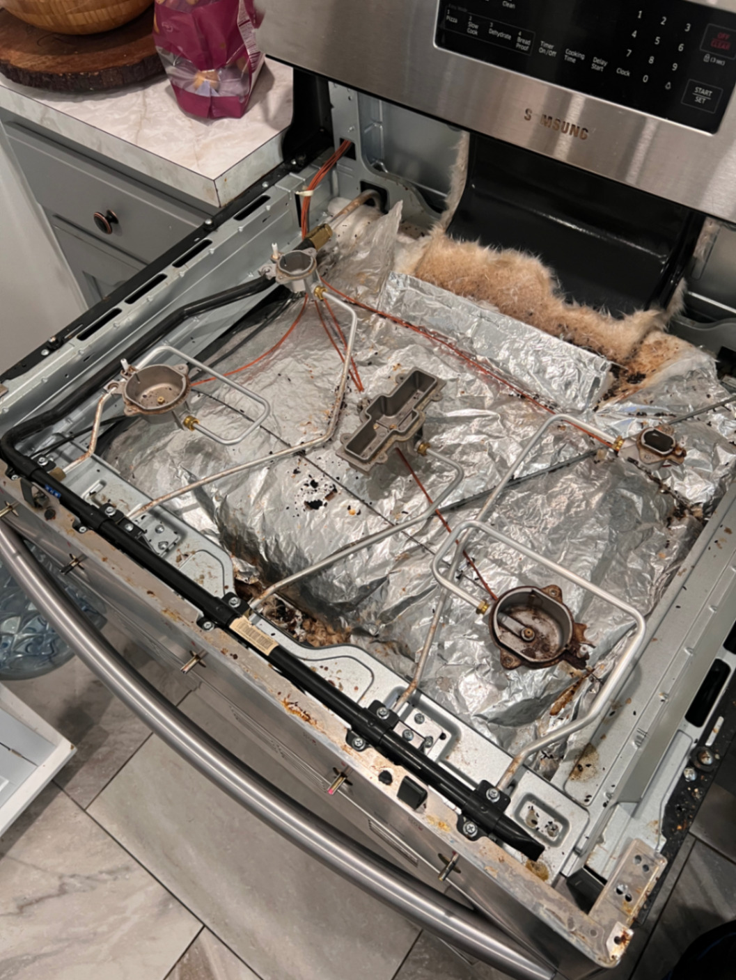 Gas range top removed for internal burner and igniter service